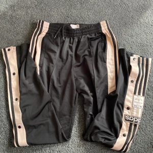 Adidasbyxor  - Säljer dessa svarta och rosa/beiga Adidasbyxor. Knappt använda. Finns 3 mindre fläckar på ena benet därför det låga priset, men de syns inte om du verkligen inte letar. I övrigt i kanonbra skick. Kan skickas mot fraktavgift. 