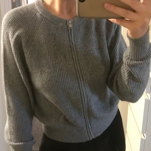 bikbok Stickad kofta  - Grå stickad kofta med dragkedja från bikbok. Väldigt mjukt material. Köpt för flera år sedan men använd 1 gång, säljer pga använder ej.