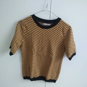  - Tröja i bärnstensgul och svart, använd få gånger, köpt på Pull&Bear. Går ned till ovanför rumpan.