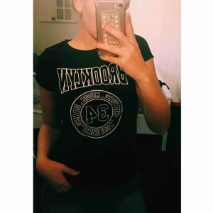  - En svart t-shirt med skurning vid höfterna som du kan se på bild nummer 2 