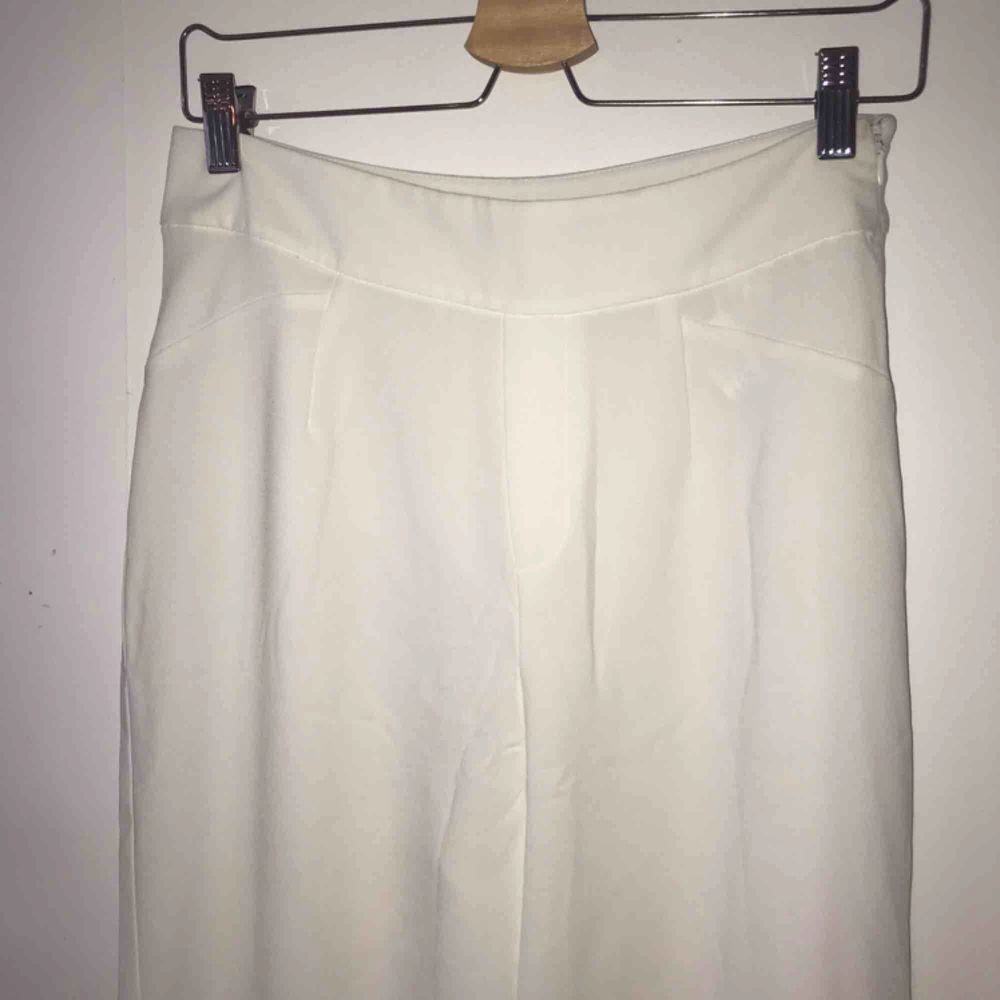 Vita kostymbyxor i något kortare modell och silkigt material. Köpta på Bershka. Storlek 38 . Jeans & Byxor.