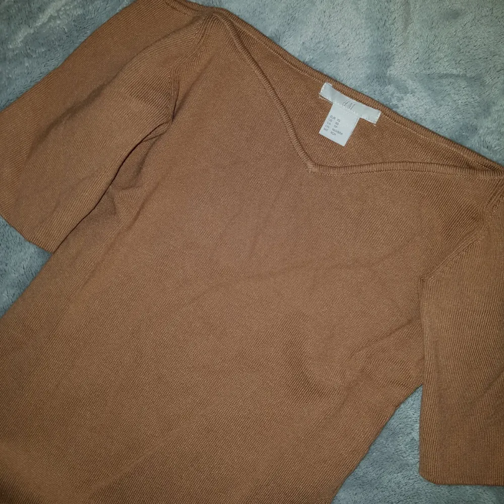 H&M Camel Off The Shoulder Sweater.  Topp, Skick: Som ny, använt 1 gång. (+ 36kr frakt).  * *Short sleeves. Fitted. Size XS. Measured across: shoulder to shoulder 14in, armpit to armpit 13in, waist 11.5in, sleeve 7.5in, length 20in*  Sista bilden är lånad men så ni ser bättre hur toppen ser ut. Den är tjockare i tyget, påminner om bandage tyg. Perfekt till hösten/vintern. . Toppar.