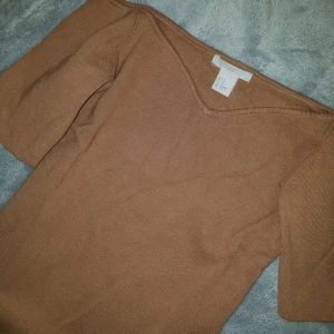  - H&M Camel Off The Shoulder Sweater.  Topp, Skick: Som ny, använt 1 gång. (+ 36kr frakt).  * *Short sleeves. Fitted. Size XS. Measured across: shoulder to shoulder 14in, armpit to armpit 13in, waist 11.5in, sleeve 7.5in, length 20in*  Sista bilden är lånad men så ni ser bättre hur toppen ser ut. Den är tjockare i tyget, påminner om bandage tyg. Perfekt till hösten/vintern. 