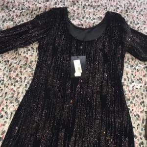 En jätte fin festkläning som är lånarmad med svart färg och glittrig köpte den för 500kr med säljer de för 250kr. Köparen står för frakt.