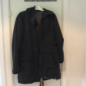 Esprit jacka  - Jacka med mjukt grått foder. Använd men i gott skick. Längre modell som slutar strax efter knäna. Luva.