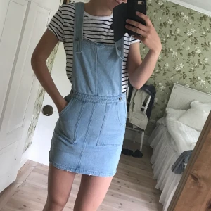 Hängselklänning i jeans  - Hängselklänning i jeans med slitningar. Säljs pga för liten.