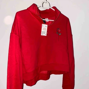  - Röd tröja/crew neck med ros på i storlek L. Aldrig använt☺️Materialet är mjuk och tjock. Frakten är inräknad i priset och om ni har frågor är det bara att skriva☺️ Betalning via swish💕