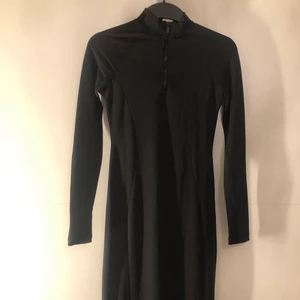 En lång klänning med dragkedja - En svart lång klänning med dragkedja på framsidan. Jätte snygg på. Den går ner över knäna. Aldrig använd.