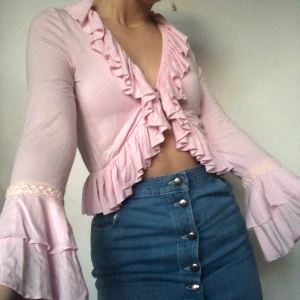 Kofta - Gulligaste rosa koftan med volanger! Visas på en s men är stretchig så skulle säker passa en m eller s också beroende på önskar passform. Håller fast i mitten med en liten säkerhetsnål! Skriv privat vid intresse. Köpare betalar frakt