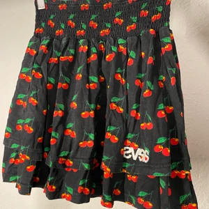 kjol svea - Mörkblå med cherries. Resårband i midjan. Två lager, ett lite längre o ett kortare. 100% bomull. 