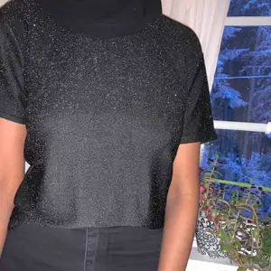 En svart glittrig t-shirt från Gina Tricot. Kan även användas som S. Aldrig använd. Kan skicka fler bilder vid förfrågan. Köparen står för frakt😊
