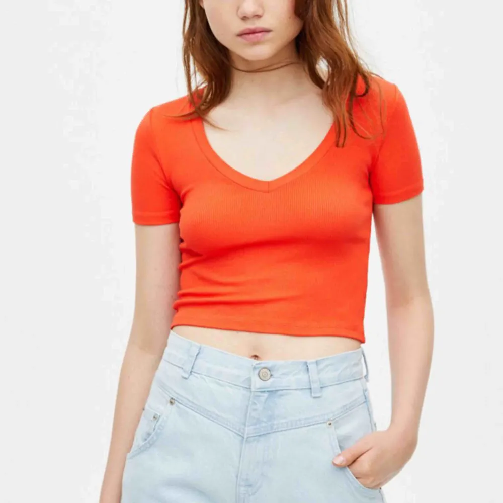 En jätte fin orange croppad t-shirt från bull & bear som tyvärr har blivit för liten och kort för mig. Den är i bra skick då jag har bara använt den ett fåtal gånger . T-shirts.