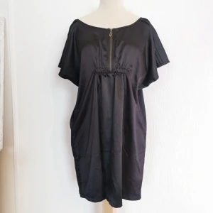  - Vacker svart klänning/tunika. Märke: ZE-ZE. Storlek: L men kan användas som M även. Skick: oanvänd med prislapp kvar, ordinarie pris 399:-. Pris: 150 kronor eller bud. Frakt: Betalas av köparen. 