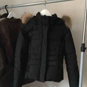  - Woolrich Jacka Svart storlek XS kan även passa S i mycket fint skick! Inköpt i Sturegallerian för ca 5000kr  Sitter väldigt fint på samt är väldigt varm och fin. Säljes då den tyvärr blivit förliten!