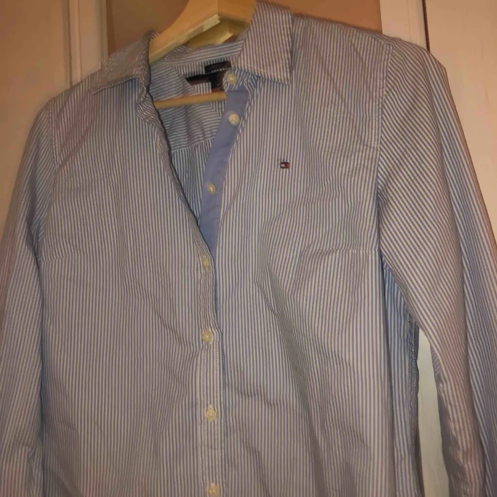 Jätte snygg och stilren blå-vit randig skjorta från Tommy Hilfiger! Jätte snygg bara sådär med jeans eller så kan man också styla med en stickad tröja över! Ttyvärr växt ur den men den är sparsamt använd✌🏼. Skjortor.