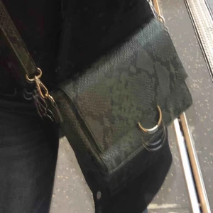  - Grön ormväska med silvriga detaljer. Väldigt bra skick. Säljes pga att den används för lite!