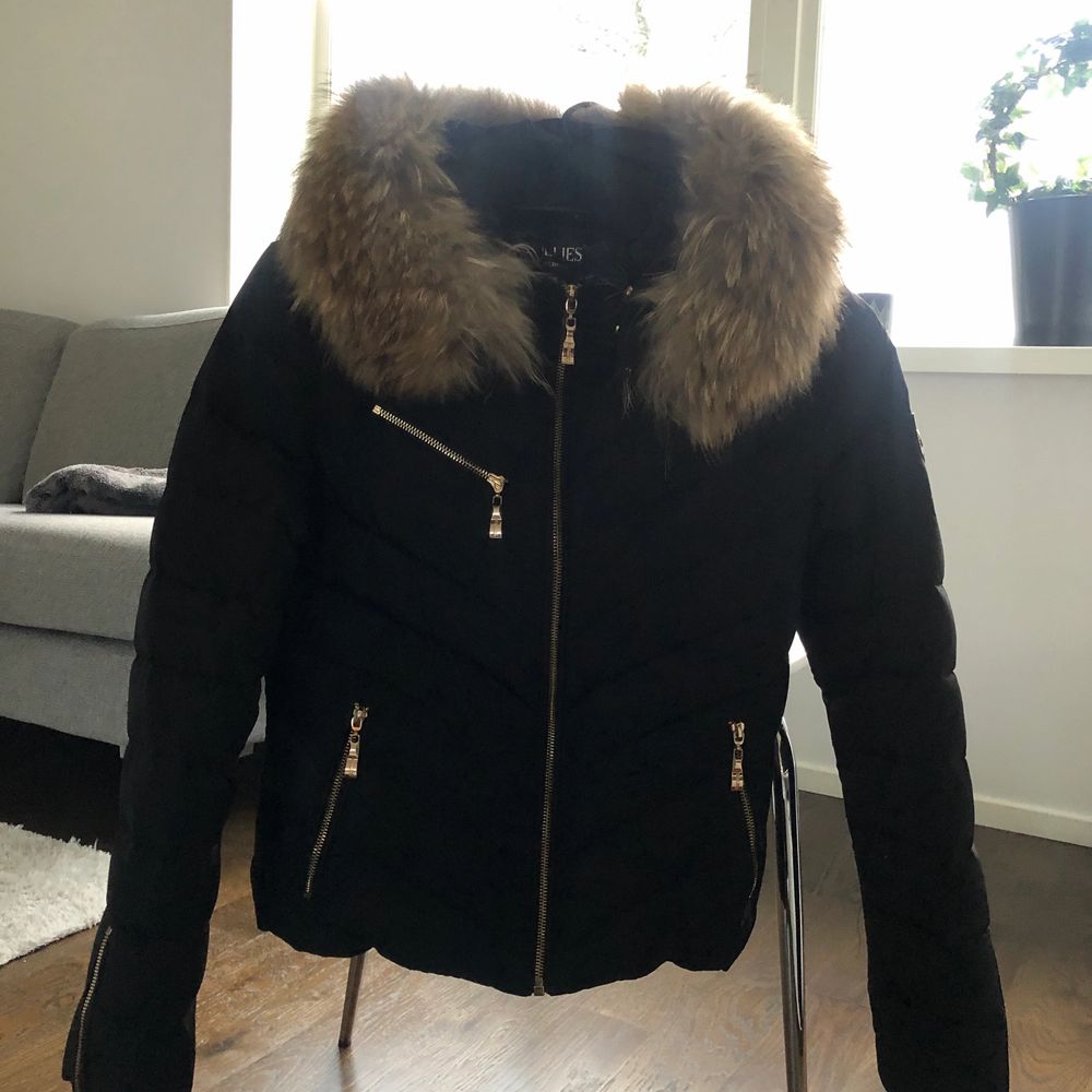 Supersnygg dunjacka från Hollies med en stor och härlig pälskrage av äkta päls. Chatel är en kortare och något nättare dunjacka än de andra från Hollies. Jackan har två fickor fram vid höften och en bröstficka, alla med guldiga dragkedjor. Chatel dunjacka från HOLLIES är perfekt för skidsemestern eller om man vill ha en lite nättare vinterjacka med samma värmande efftekt då fyllningen består av 80%dun och 20%fjädrar. Storlek: 36 Färg: Svart Material: Ytter/inner shell: 100% polyester Stoppning: 80% anddun 20% andfjäder Äkta Päls: Raccoon, tvättbjörn Tvättråd: Kemtvätt Köpes år: 2016 Originalpris: 3500kr . Jackor.