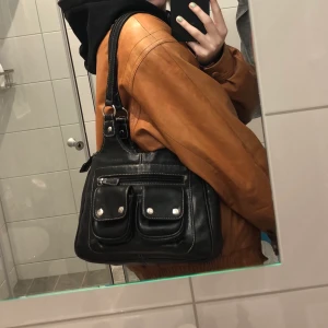 Svart väska   - Svart väska köpt på second hand! Liten men ändå rymlig med många fack! 