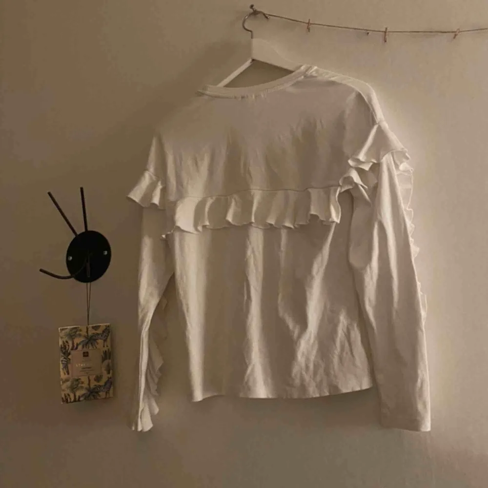 En fin vit långärmad volang tröja från hm. Kommer ej till användning. Köparen står även för frakt:) . Toppar.