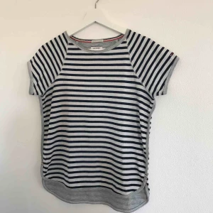 Randig Tommy Hilfiger T-shirt  - Fin vit och marinblå randig t-shirt från Tommy Hilfiger i lite tjockare material. Ursprungspris ca 900kr. Passar även S. Fint skick! Köpare står för eventuell frakt 💗⚡️