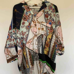  - Riktigt ball blus med mönster. Oversized passform med skärning i slutet av ryggen. Känns lyxig i satin. Storlek UK 14, alltså EU 42. Skickas spårbart och fraktkostnad på 63kr tillkommer! 💝