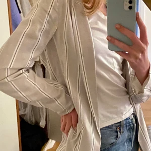 Kavaj - Säljer denna snygga kavaj från HM i storlek 34. Är beige me blåvita ränder. Frakt tillkommer på 50:)