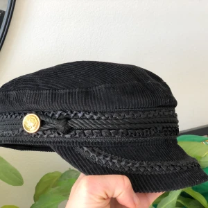 Emilkeps med detaljer - Supersnygg emilkeps i mörkblått och med gulliga detaljer. 