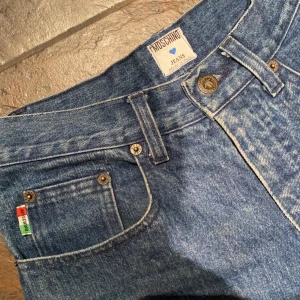Jeans från Moschino! - Raka jeans från Moschino. Har klippt av de sjäv för att passa min längd (165). Inget större fel på dem. Säljer då de inte kommer till användning. Skulle säga att de passar en 34/36 beroende på hur man vill att de ska sitta. På mig sitter de tight (36/38)