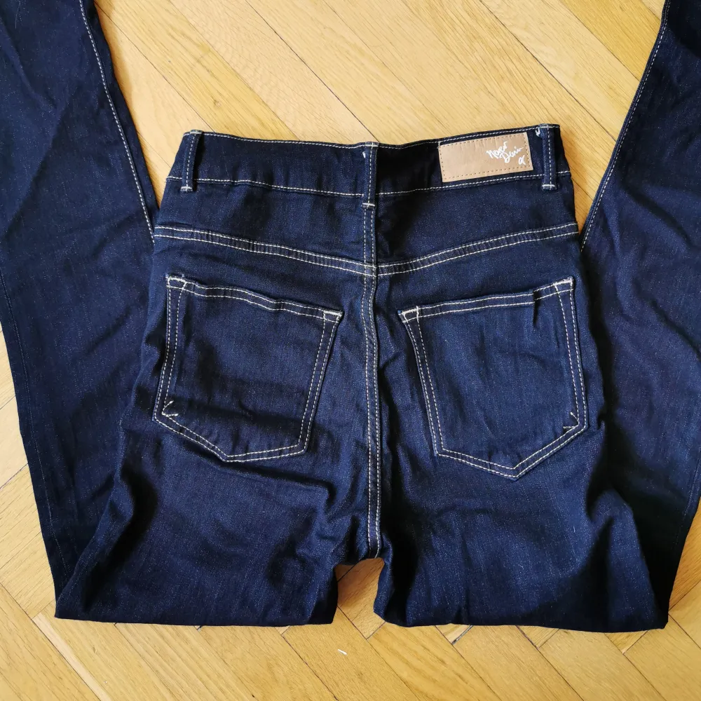 Mörkblå skitsnygga jeans av märket Never Denim köpta på BikBok. Hög midja. Aldrig använda då de är för små för mig. Storlek 26/33. Jeans & Byxor.