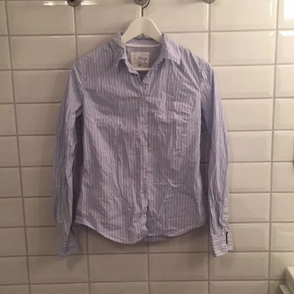 Jag säljer min ljusblårandiga skjorta ifrån H&M i storlek 38 då den knappt blivit använd. Den är i mycket bra skick, som ny. Jag tycker den är storleksenlig!. Skjortor.