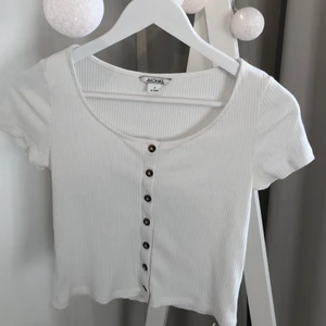 Vit ribbad topp - En vit ribbad topp med knappar från Monki. Storlek s. Frakten ingår i priset!!