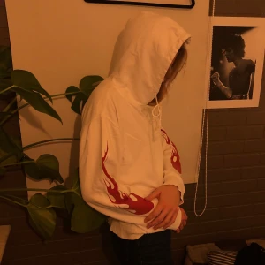 Vit Hoodie med röda flammor  - Vit hoodie med röda flammor längs armarna köpt på Brandy Melville. Onesize men ungefär 36, skriv för mer info! 