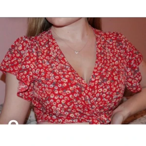 Omlott topp - Röd omlott topp med vita blommor. Aldrig använd,Har du frågor eller vill få fler bilder så skriv😊