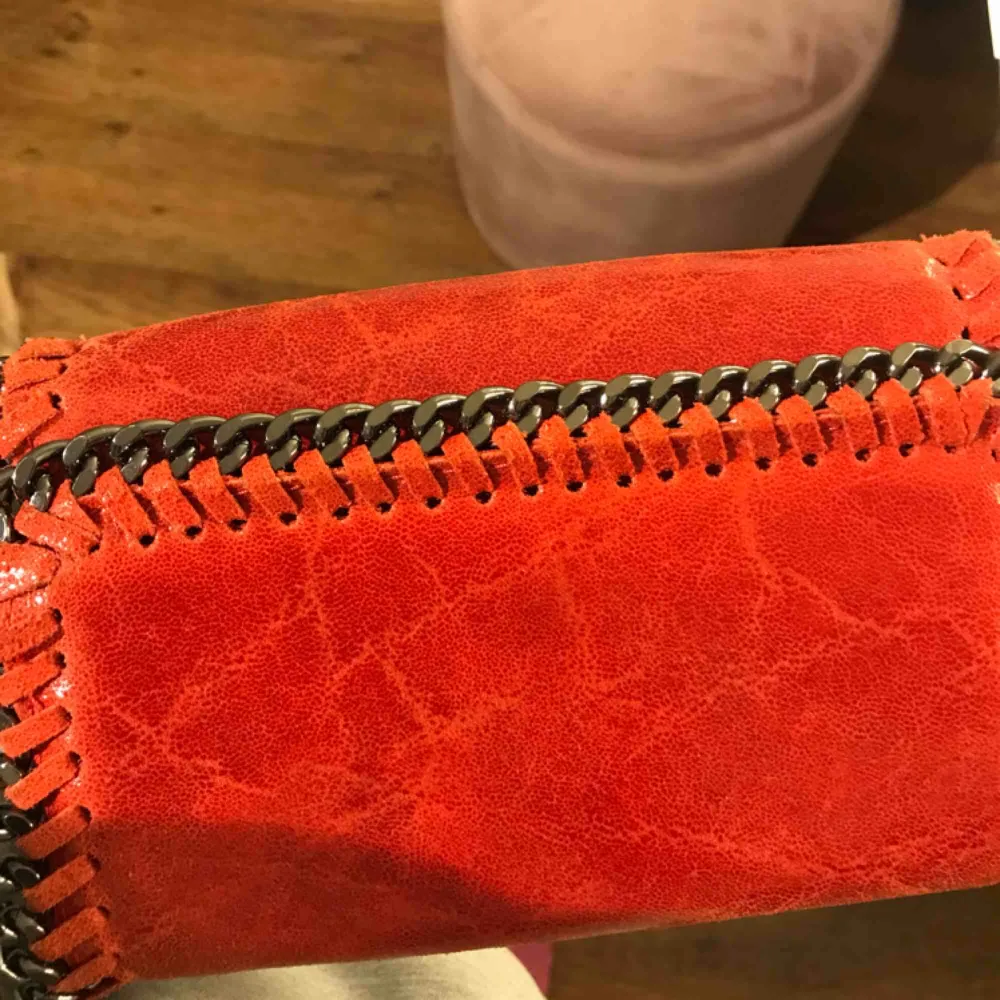 Liten handväska i äkta läder köpt i Italien. Fin röd färg och går att använda banden på två sätt.. Väskor.