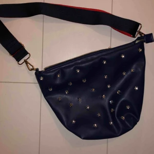 Väska  - Ny helt oanvänd väska. Blå med guldiga detaljer samt stjärnformade strassar. Köpare står för frakt💚