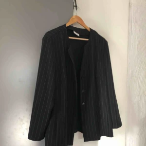  - En lite oversized kritstreckad kavaj, jag är storlek 36 och då är den lite stor, hittar inte någon storlekslapp men skulle gissa 38.