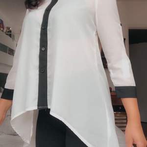 Supersnygg svartvit skjorta som är kort framifrån och längre bakifrån. Kan manipuleras till att passa som både ett löst eller tajt plagg. 