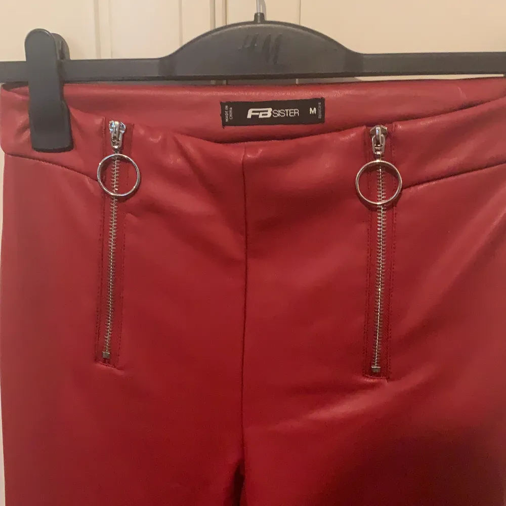 Röda skinnbyxor med väldigt fin detalj aldrig använd i strl M sätter sig jätte fint på kroppen. Jeans & Byxor.