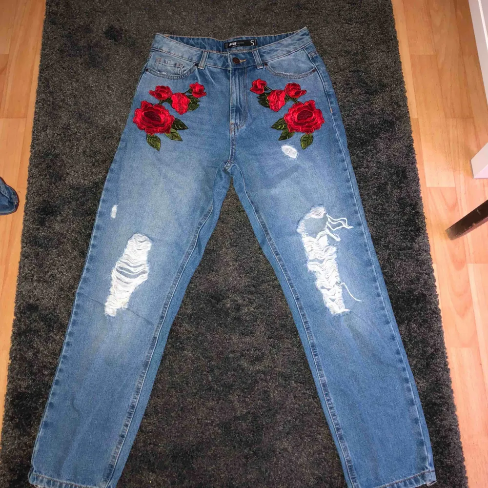 Jeans med slitningar och rosor som detaljer. Jeans & Byxor.