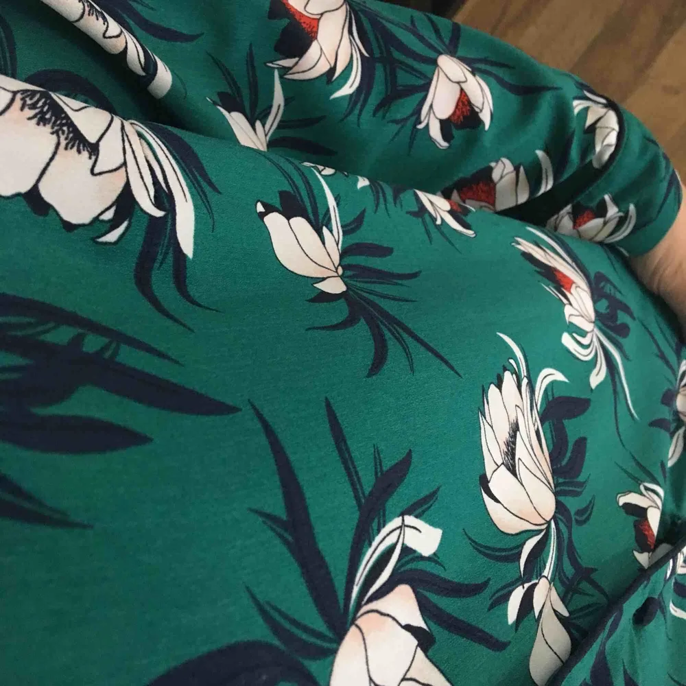 Grön blus i ”pyjamas- modell” med blommigt mönster. Jättefin sommarblus som tyvärr kommer till för lite användning. Blusen är i jättefint skick! . Blusar.