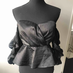  - Festlig topp i svart silke med pösiga ärmar. Dragkedja baktill. Bara axlar då ärmarna sitter över armbågen. Aldrig använd. (OBS!!! Har denna även i champagne, skriv för fler bilder). Köparen står för frakten 🖤✨