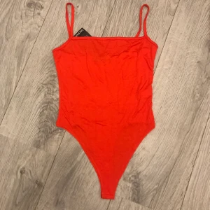 Röd body med lapp kvar! - Röd body med lapp kvar! Storlek 34. Vid intresse kan eventuellt fler bilder skickas.