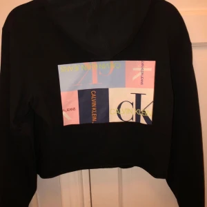 Calvin Klein hoodie - Svart lite croopad hoodie med tryck på ryggen från Calvin Klein. 