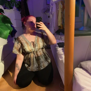 genomskinlig blus i snakeskin-mönster - en jättesöt blus i ett sorts genomskinligt snakeskin-mönster! 💚 ascool tröja som är köpt på secondhand i Estland, har tyvärr inte fått så mycket användning för denna 🥺 vet knte riktigt vilken storlek det är, men skulle säga att den fungerar för S-M! tröjan kostar 45 kronor + frakt på 30 kronor! betalning sker helst via swish 💫