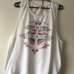 Vit linne med tryck. Storlek L - Vit linne med tryck på. Använd några gånger. Linne är i storlek L men kommer passa M. Köparen står för frakt 🚚 