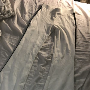 Vida yoga pants stl S - Ett par vita yoga pants med ett svart stäck längst vardera ben