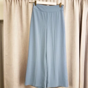  - Bekväma, underbara byxor i gråblå färg. De är ankellånga och har dragkedja i midjan som skapar perfekt passform. Aldrig använda eftersom jag inte tycker jag passar i färgen. Originalpris 349 kronor. Storlek 36.