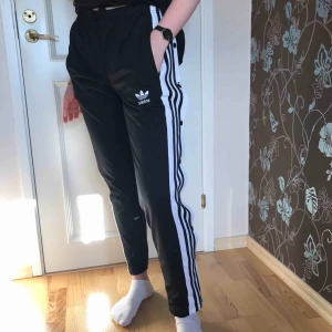  - Adidas byxor med knäppning hela vägen längs sidorna. En knapp har tyvärr lossnat men med lite sy-skillz löser en nog det väldigt enkelt. Har satt en säkerhetsnål där så länge som syns på bilden. 