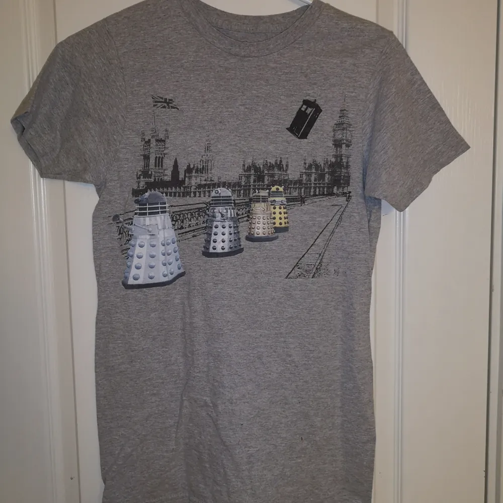 En grå t-shirt med bild från Doctor Who. Tycker mycket om den men kommer sällan till användning. Köptes på Hot Topic för 2-3 år sen. Kan hämtas i Lund eller Eslöv, annars tillkommer frakt.. T-shirts.