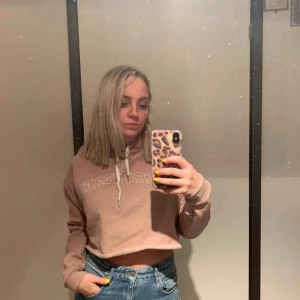  - En croppad hoodie från divided. Storleken M och färgen är gammelrosa. 